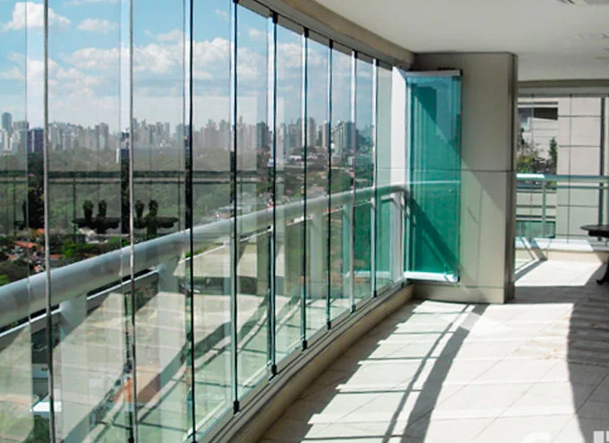 Sacada envidraçada com vista para a cidade, com fechamento em vidro e guarda corpo